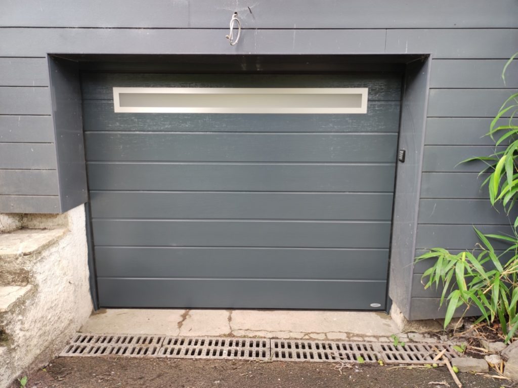 Porte-sectionnelle-motorisée-novoferm-tablier-larges-lames-avec-long-hublot-+-digicode-croix-M-DHAZE