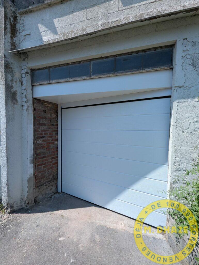 Installation d’une porte sectionnelle Novoferm avec pose en biais et  tablier large lames à Lomme (59)