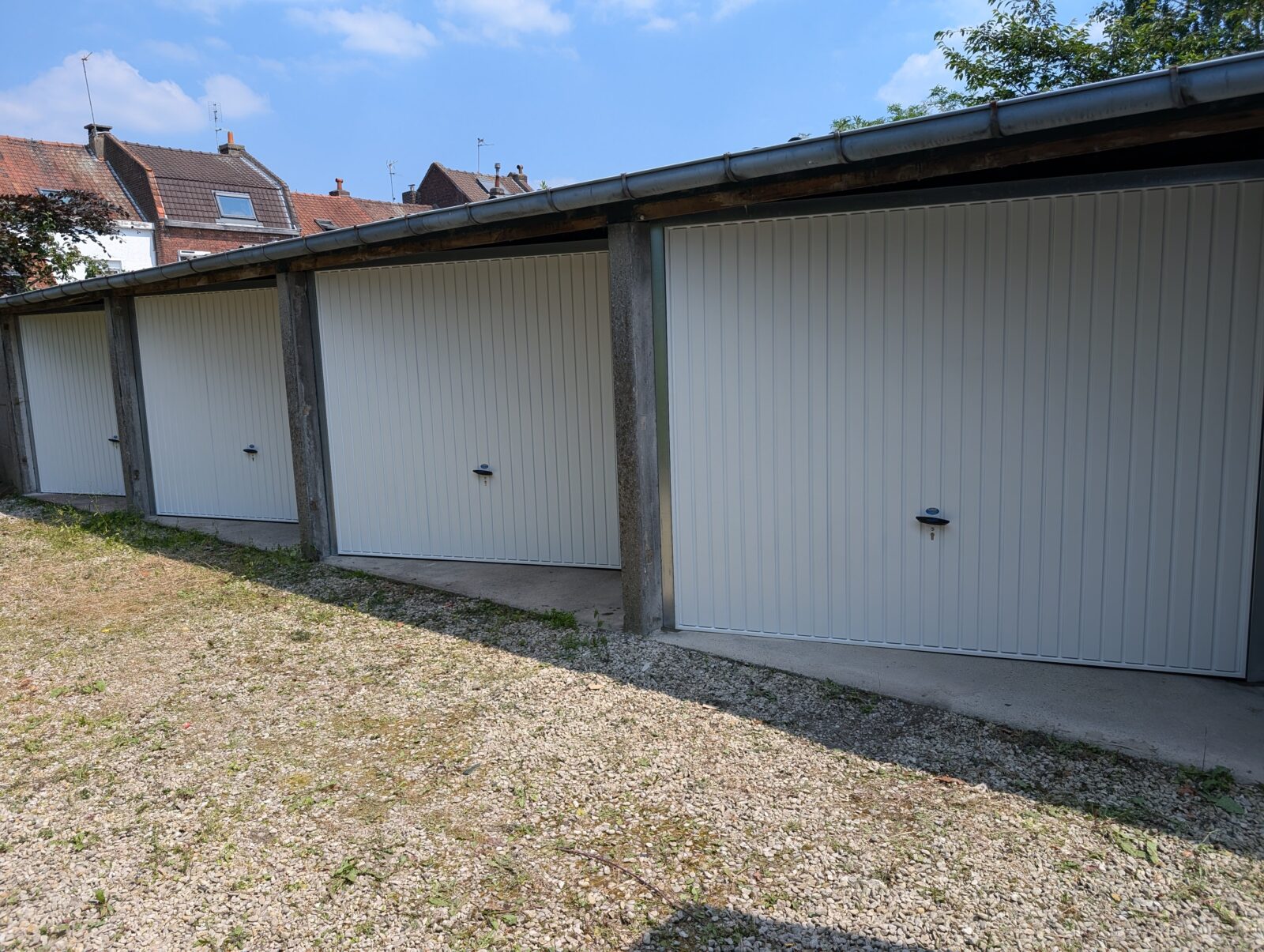 Pose en remplacement de portes de garages basculantes métalliques Novoferm. Les Ets M. Dhaze ont procédé à une pose en Biais pour des dimensions plus larges. 
