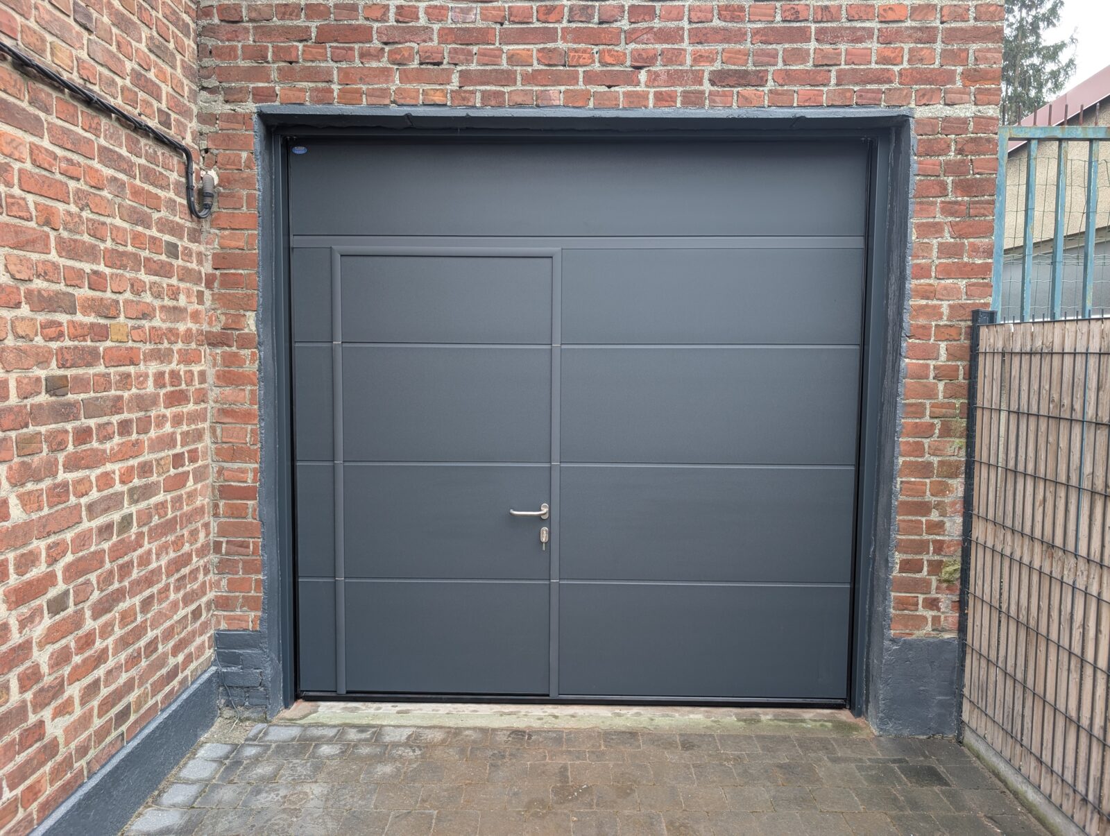 Installation d'une porte sectionnelle Novoferm avec portillon intégré fermeture 5 points à Ronchin dans la métropole lilloise (Nord)