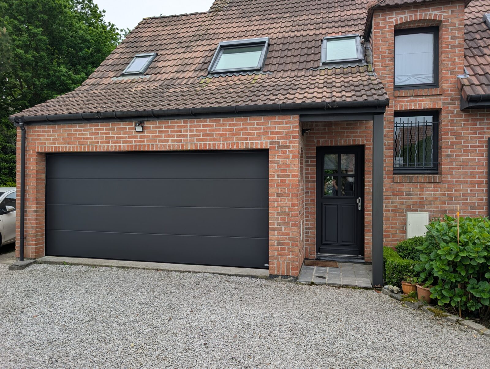 Remplacement d'une porte sectionnelle non-isolée et non rentable pour rénovation. Pose d'une porte sectionnelle isolante Novoferm pour un design plus moderne à Frelinghien (Nord)