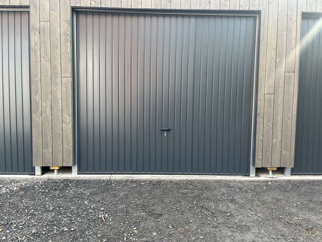 Pose de 5 portes de garages basculantes métalliques Novoferm sur carports bois en logement collectif à Quesnoy sur Deûle à proximité de Tourcoing (59).