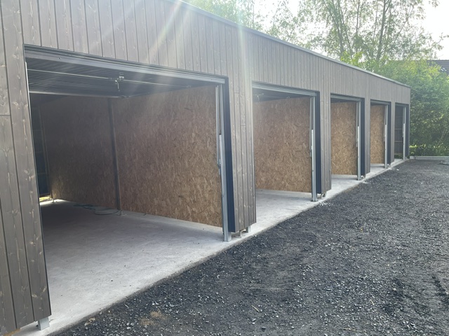 Pose de 5 portes de garages basculantes métalliques Novoferm sur carports bois en logement collectif à Quesnoy sur Deûle à proximité de Tourcoing (59).